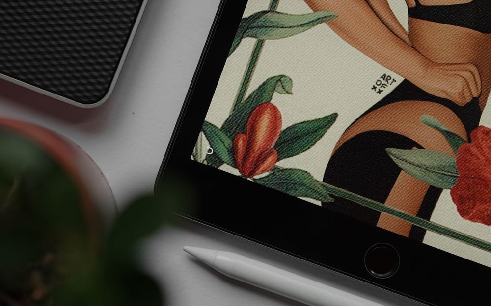 A tablet displaying a colorful floral digital illustration beside a stylus